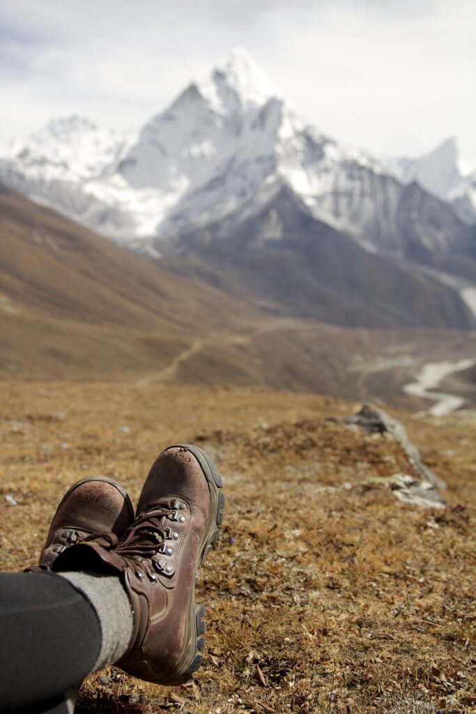 person's legs with mountains in the background
