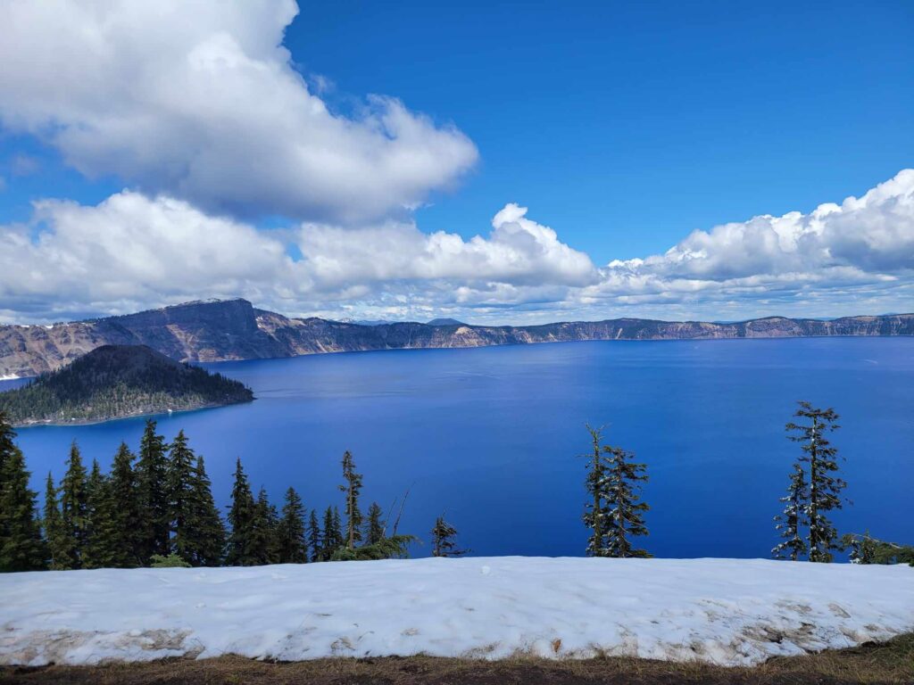 crater lake with snow on the ground
